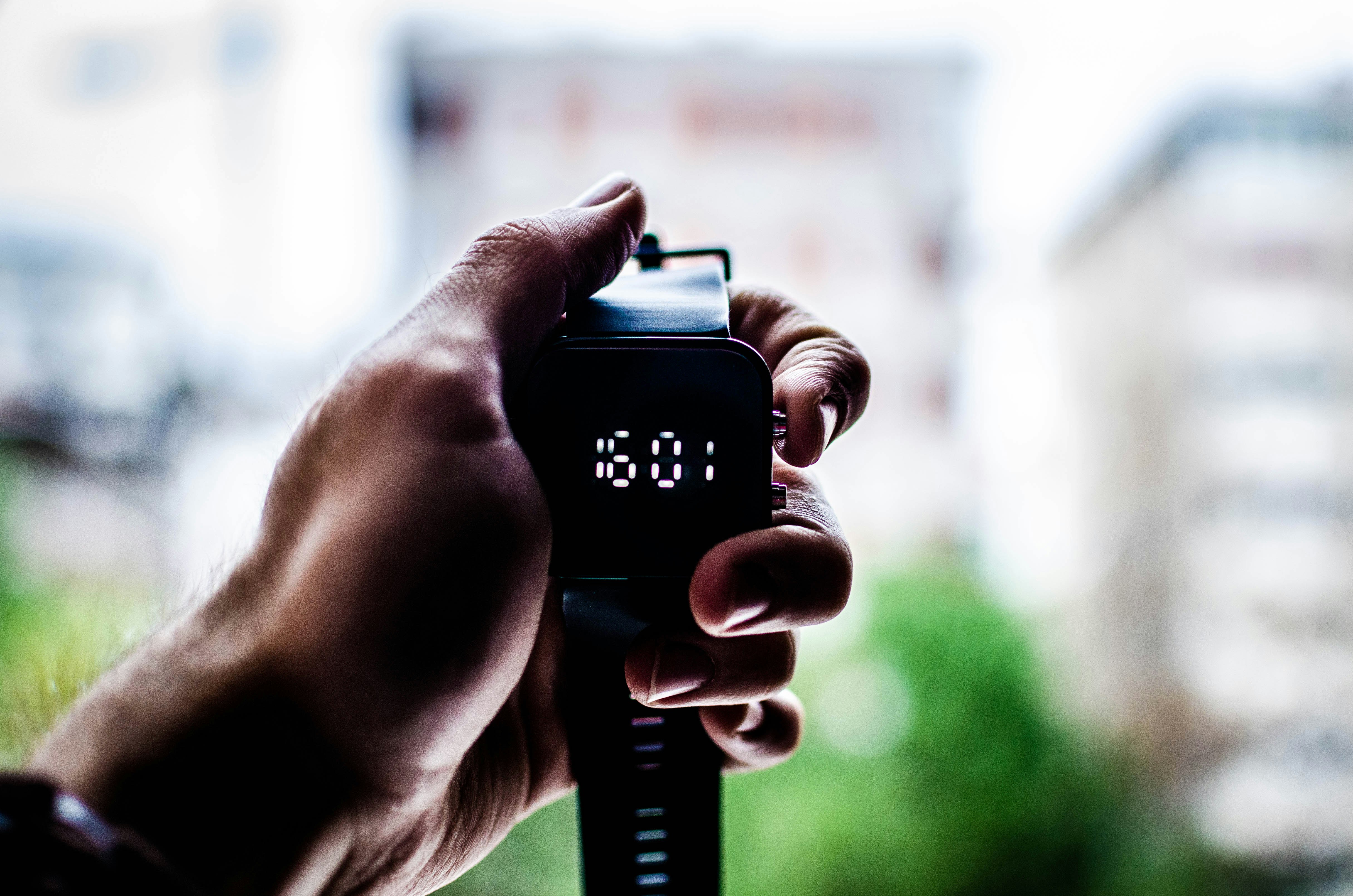 person holding digital watch